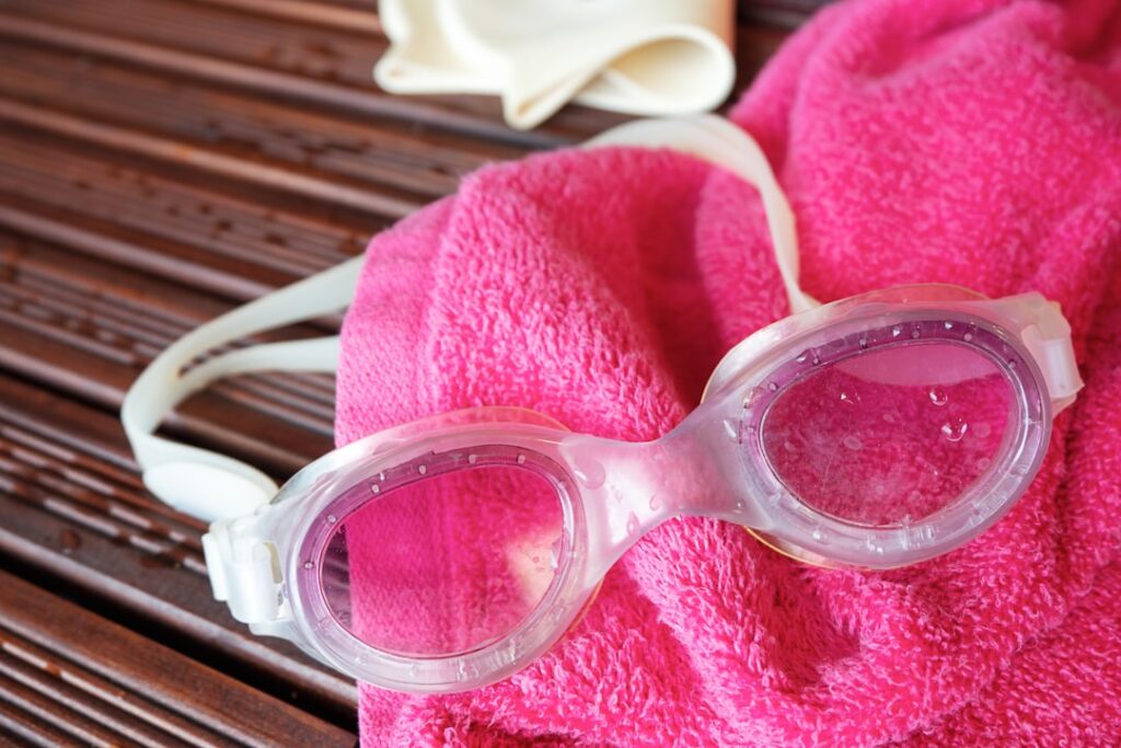 Swim goggles, towel, and a swim cap are displayed.