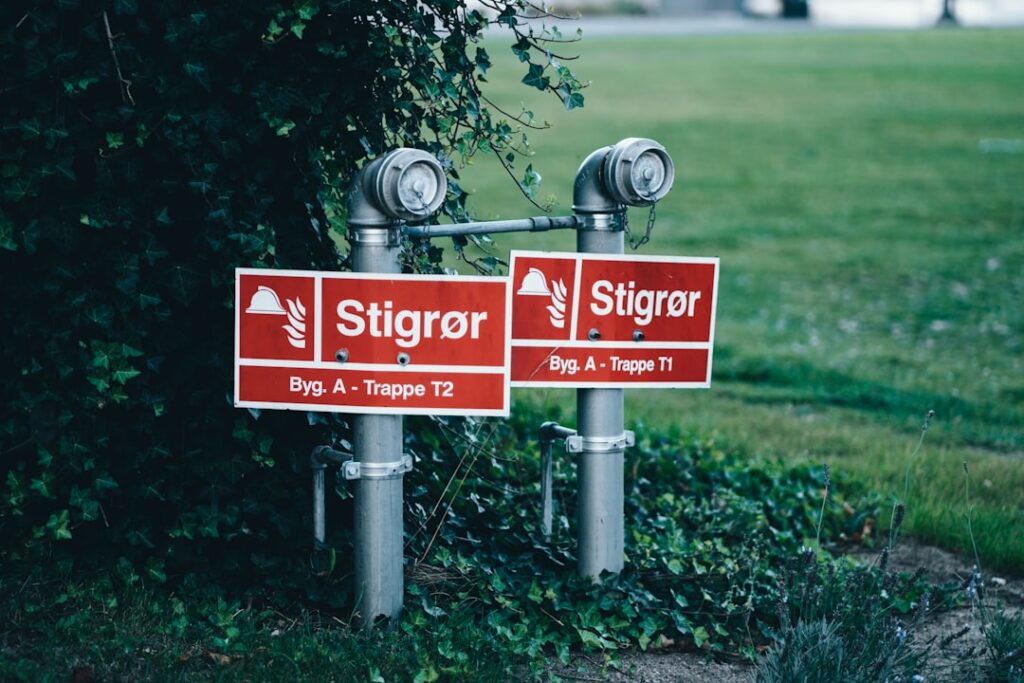Two metal pipes with red signs attached