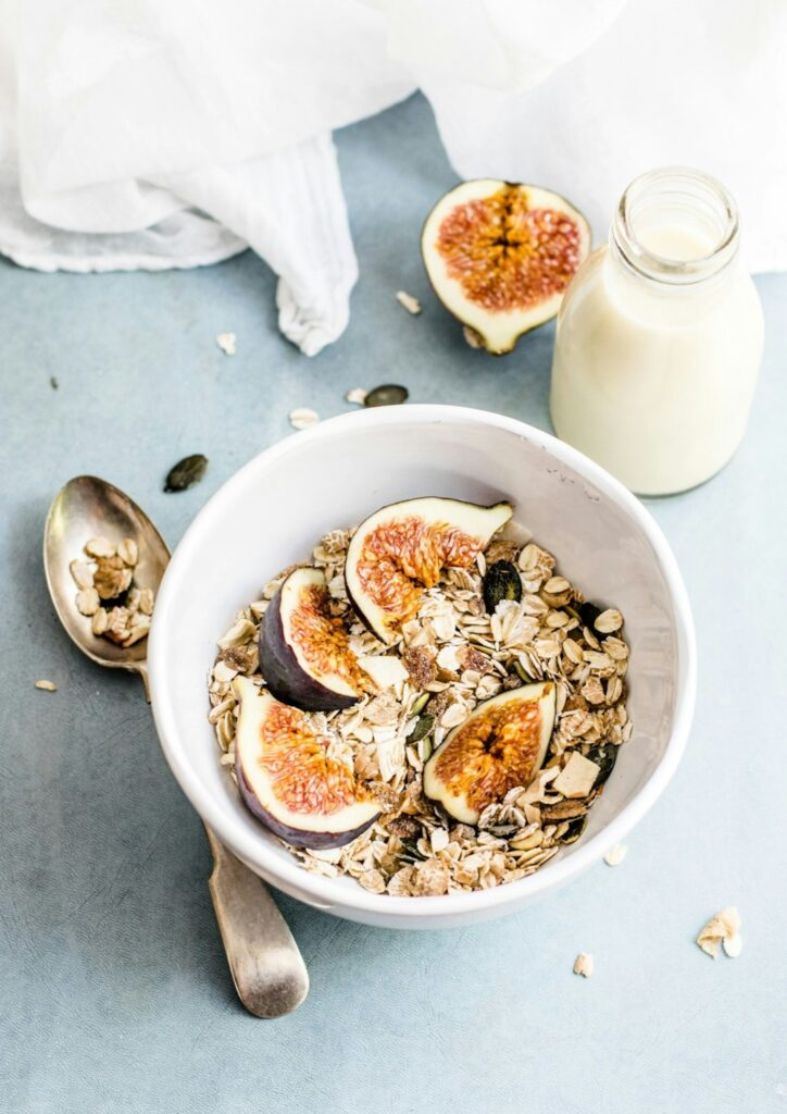 A bowl of oatmeal with figs and a glass of milk