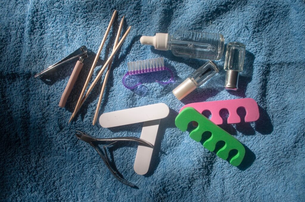 Manicure and pedicure tools on a blue towel.