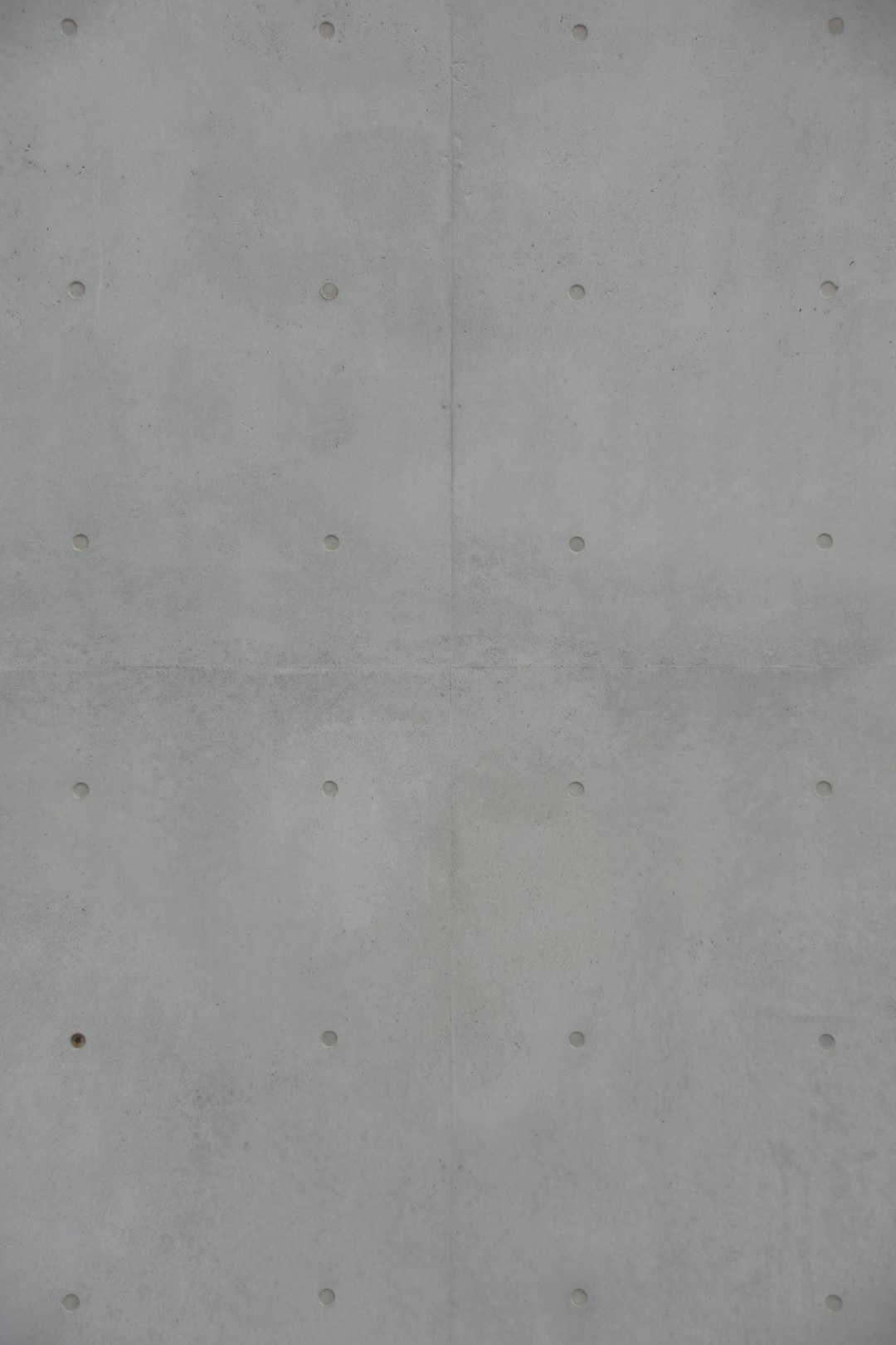 A concrete wall with small circular indentations